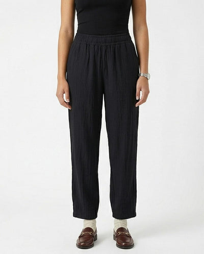 Person wearing black pants on a white background