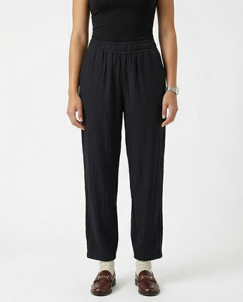 Person wearing black pants on a white background